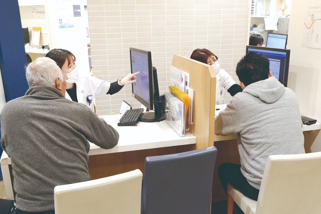 専用受付で患者に説明する技師